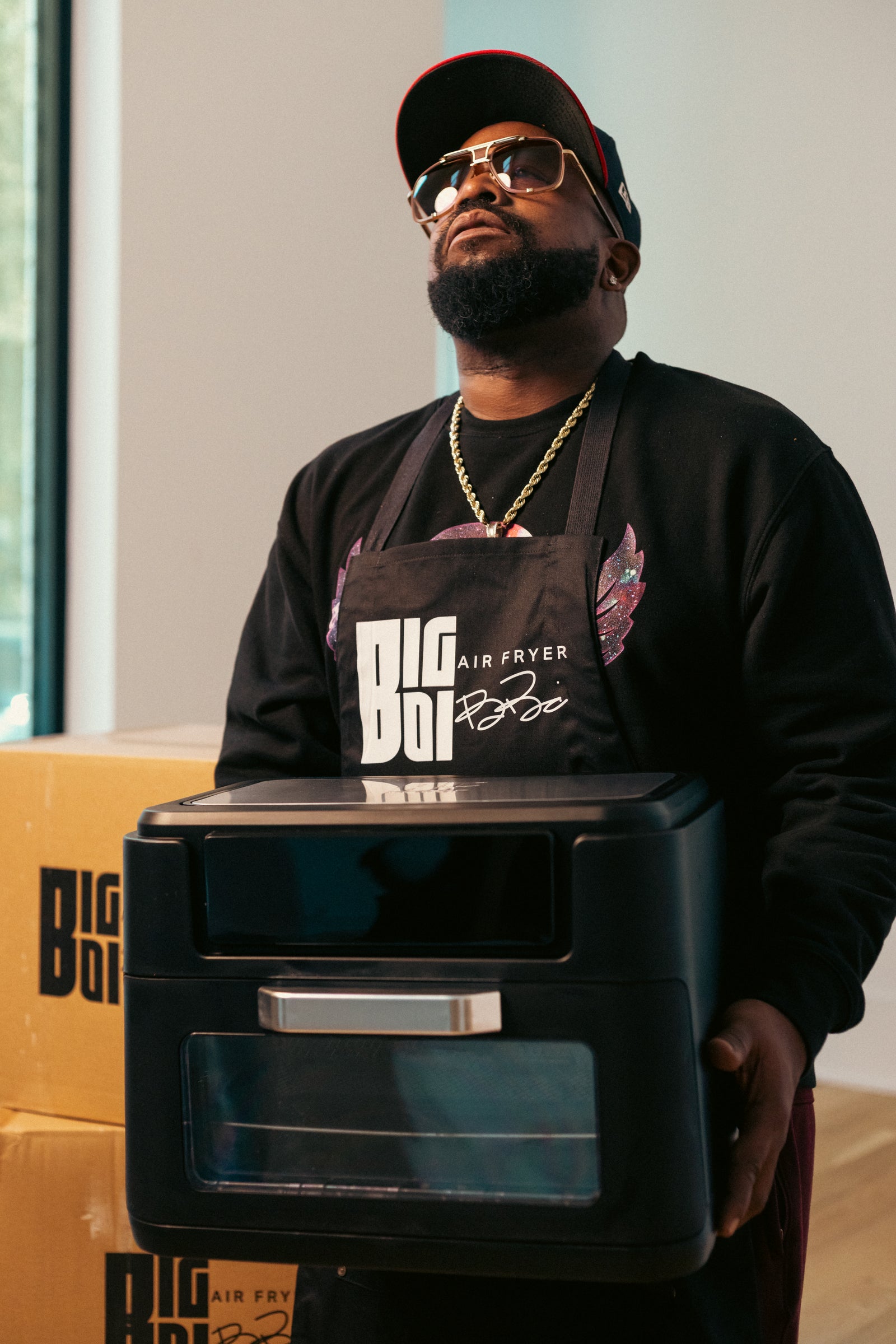 Big Boi wearing the signature apron with the Big Boi 12-quart air fryer